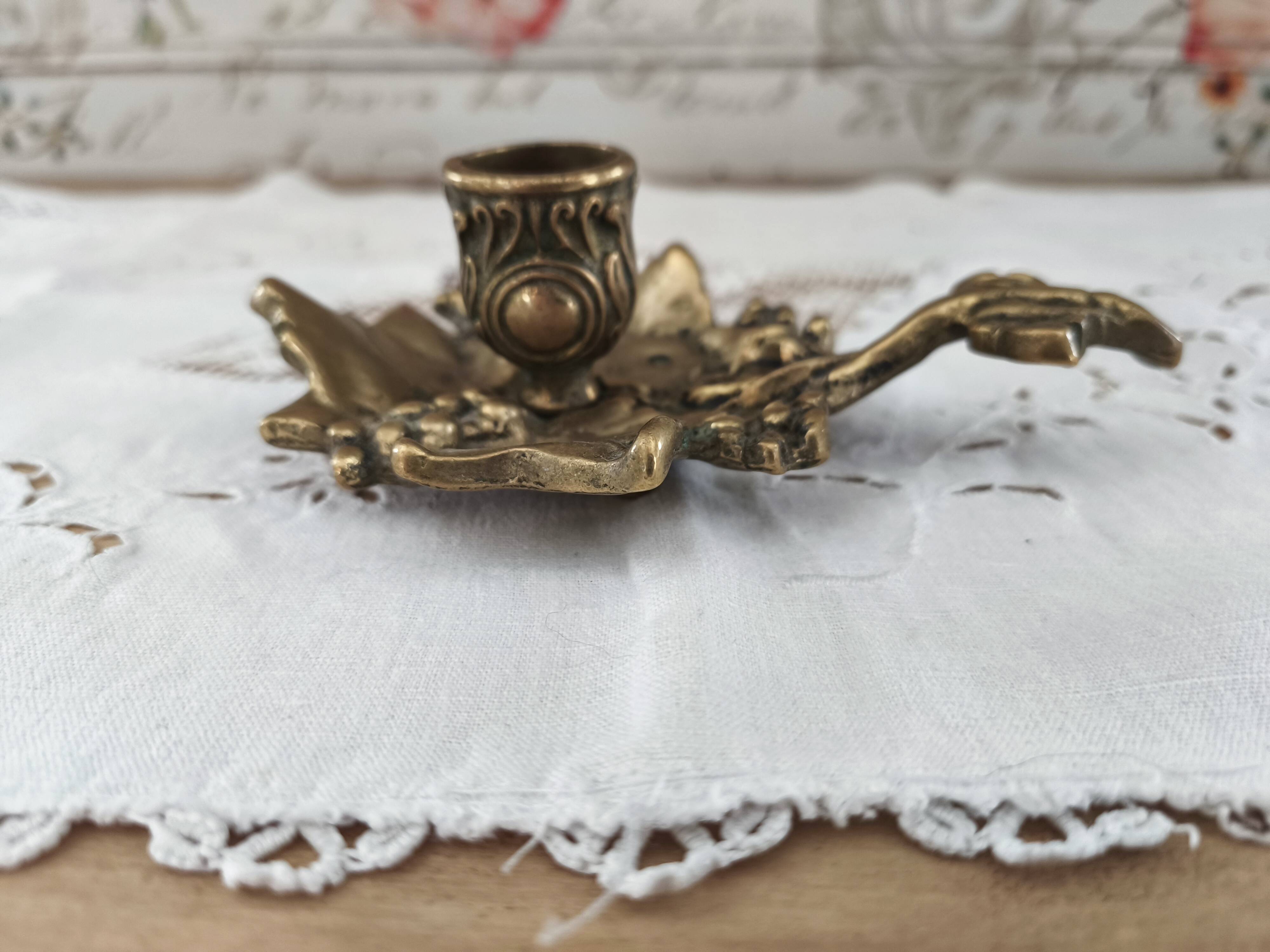 Hand-held candle holder called "cellar rat" in brass with vine leaf decoration