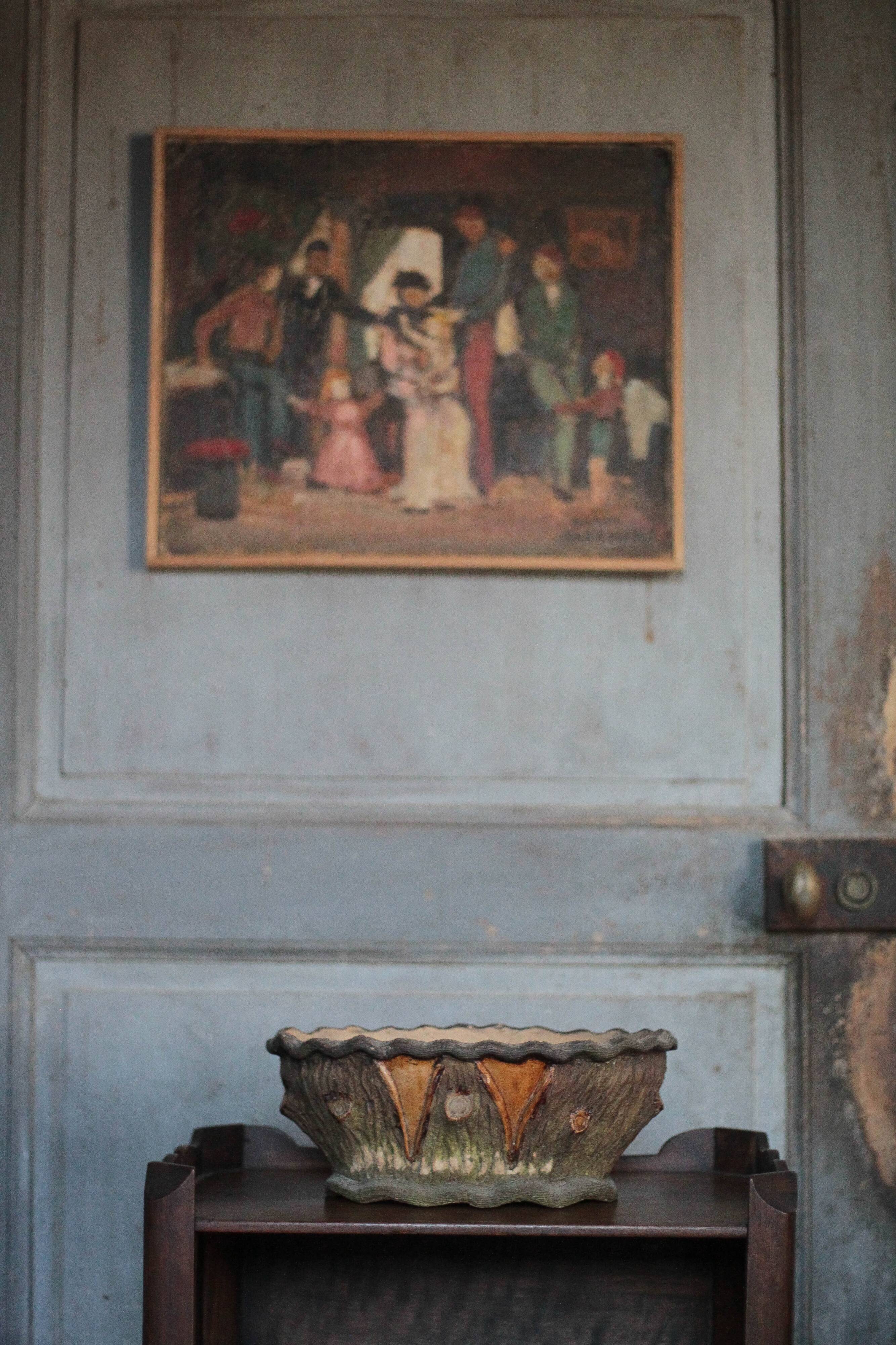 Terracotta planter in a brutalist style resembling a tree trunk, pot cover, countryside.