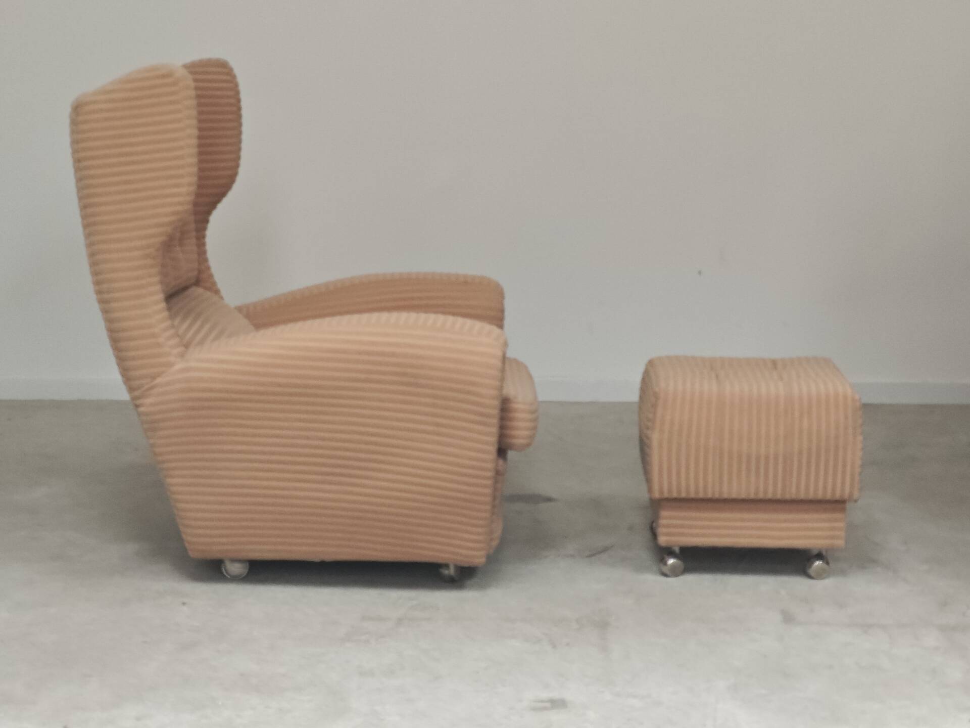 Beige wingback armchair and TVAR footrest, former Czechoslovakia.
