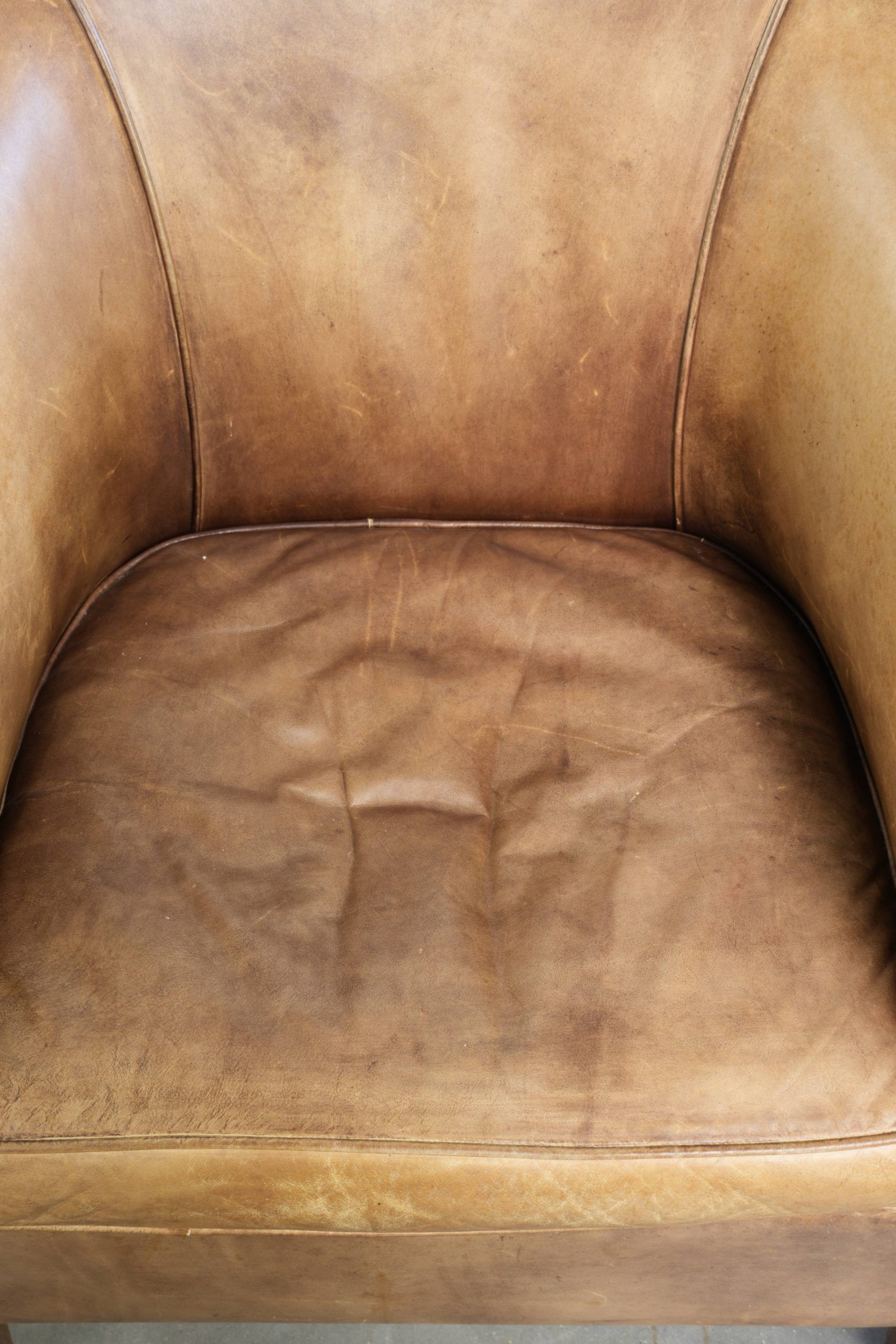Vintage cowhide club armchair in English style in a light colour scheme