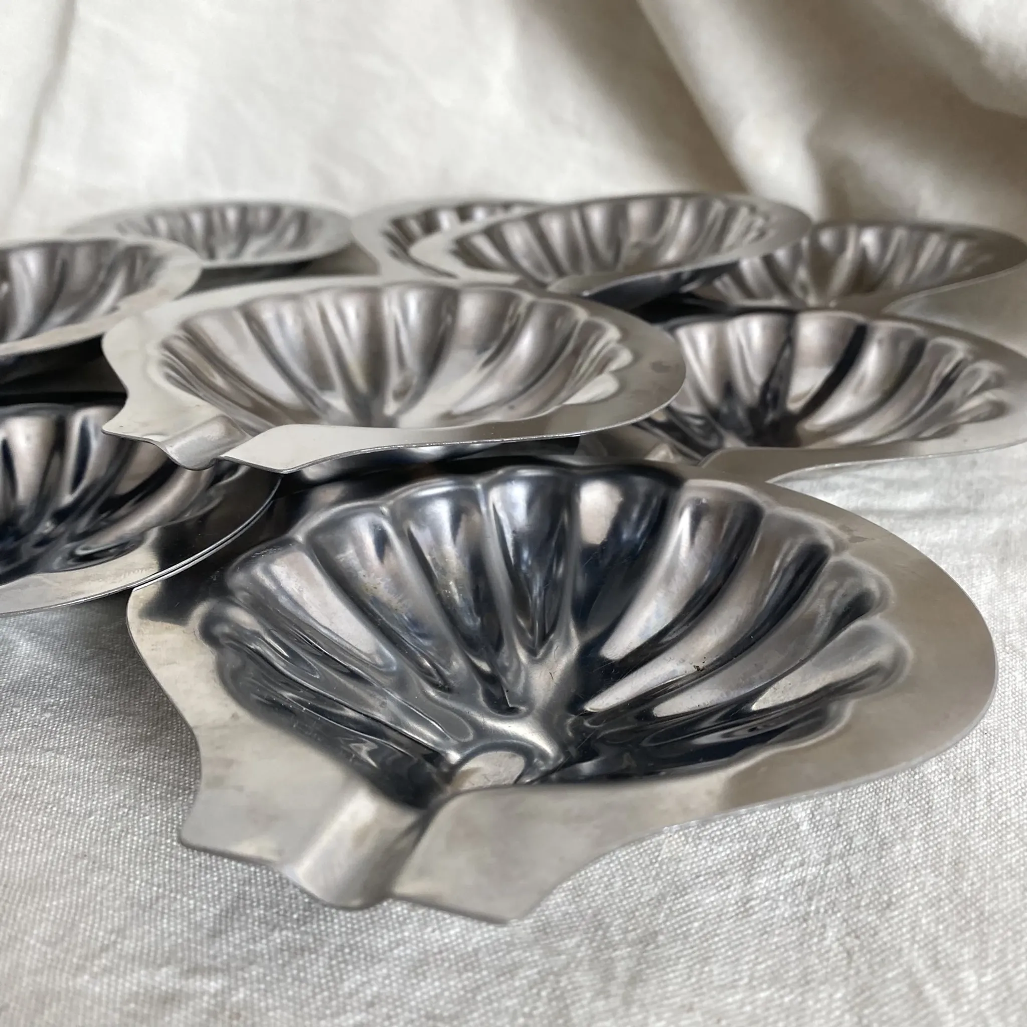 Set of 12 stainless steel scallop shells, 1970s-80s.