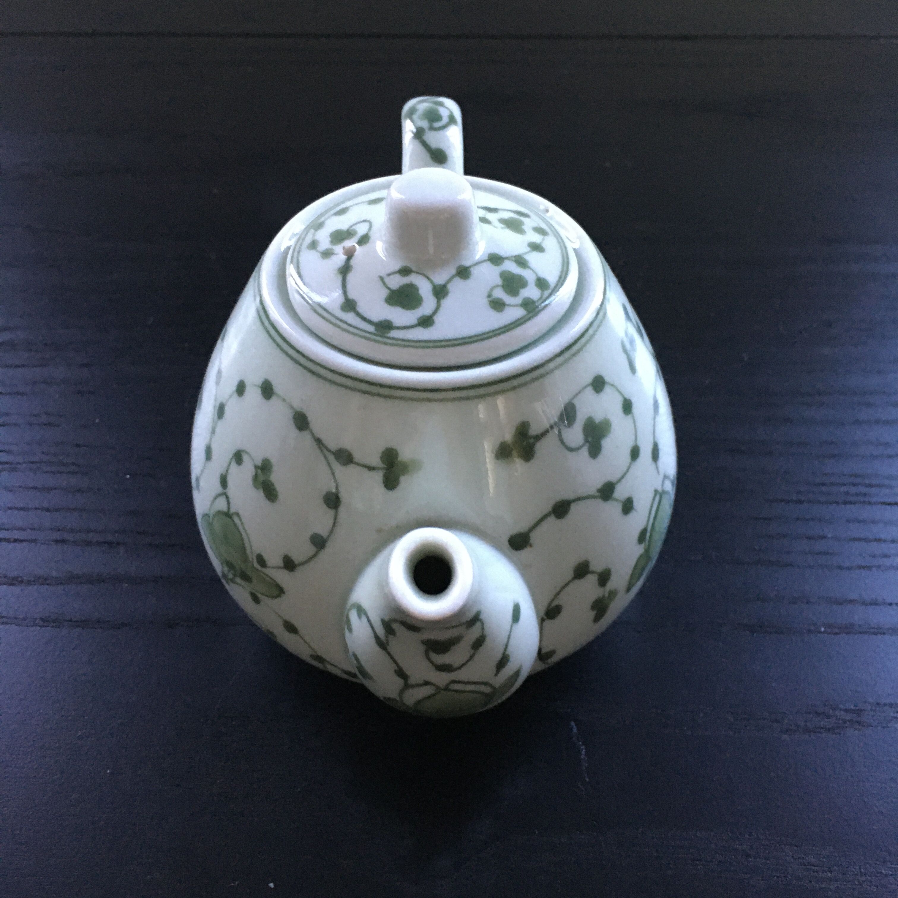 Green plant-decorated teapot