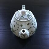 Green plant-decorated teapot