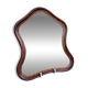 Antique wall mirror in carved wood with a wavy shape and a golden trim.