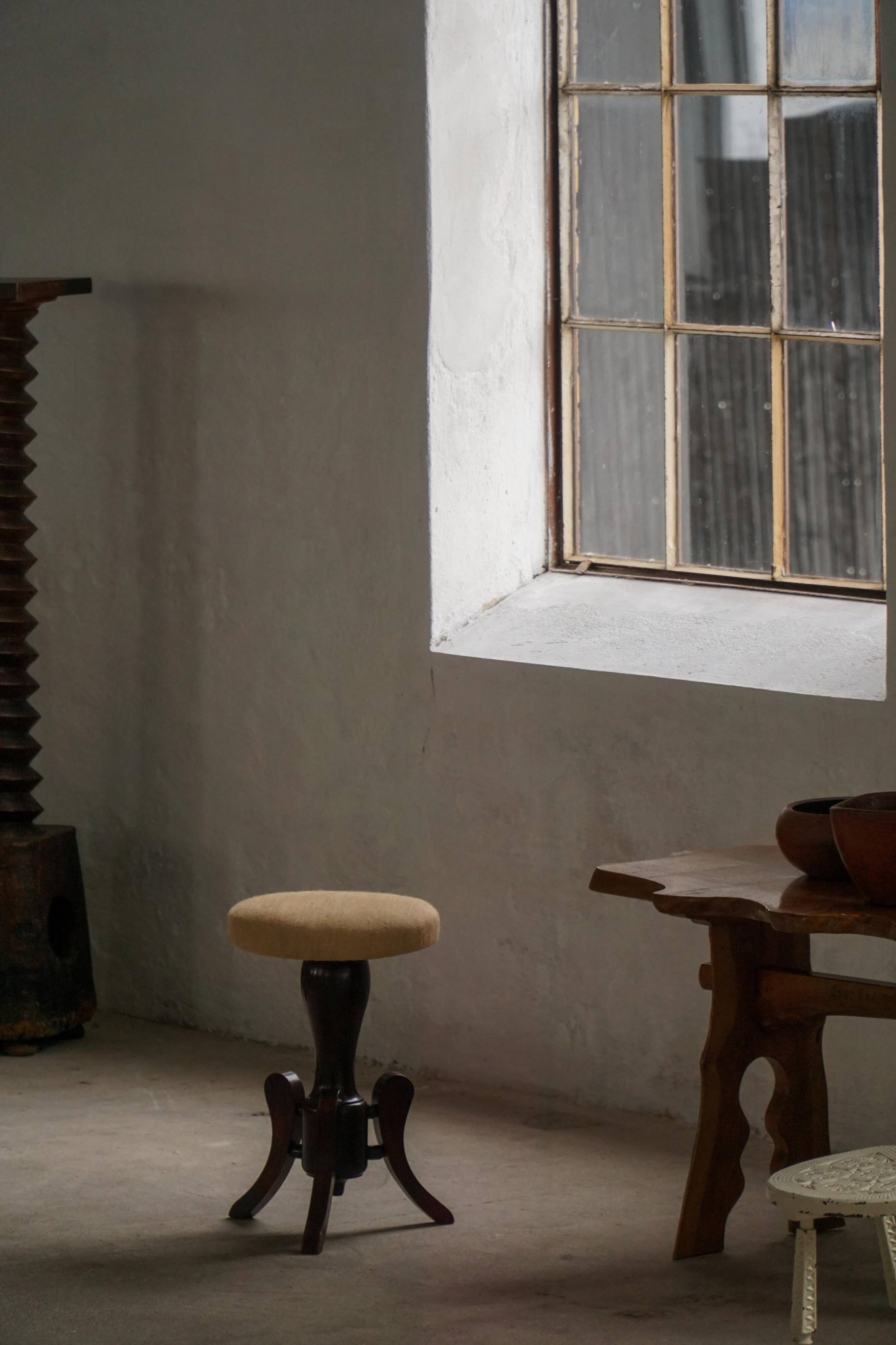 Adjustable Victorian-style piano stool with a jute fabric seat, early 20th century.