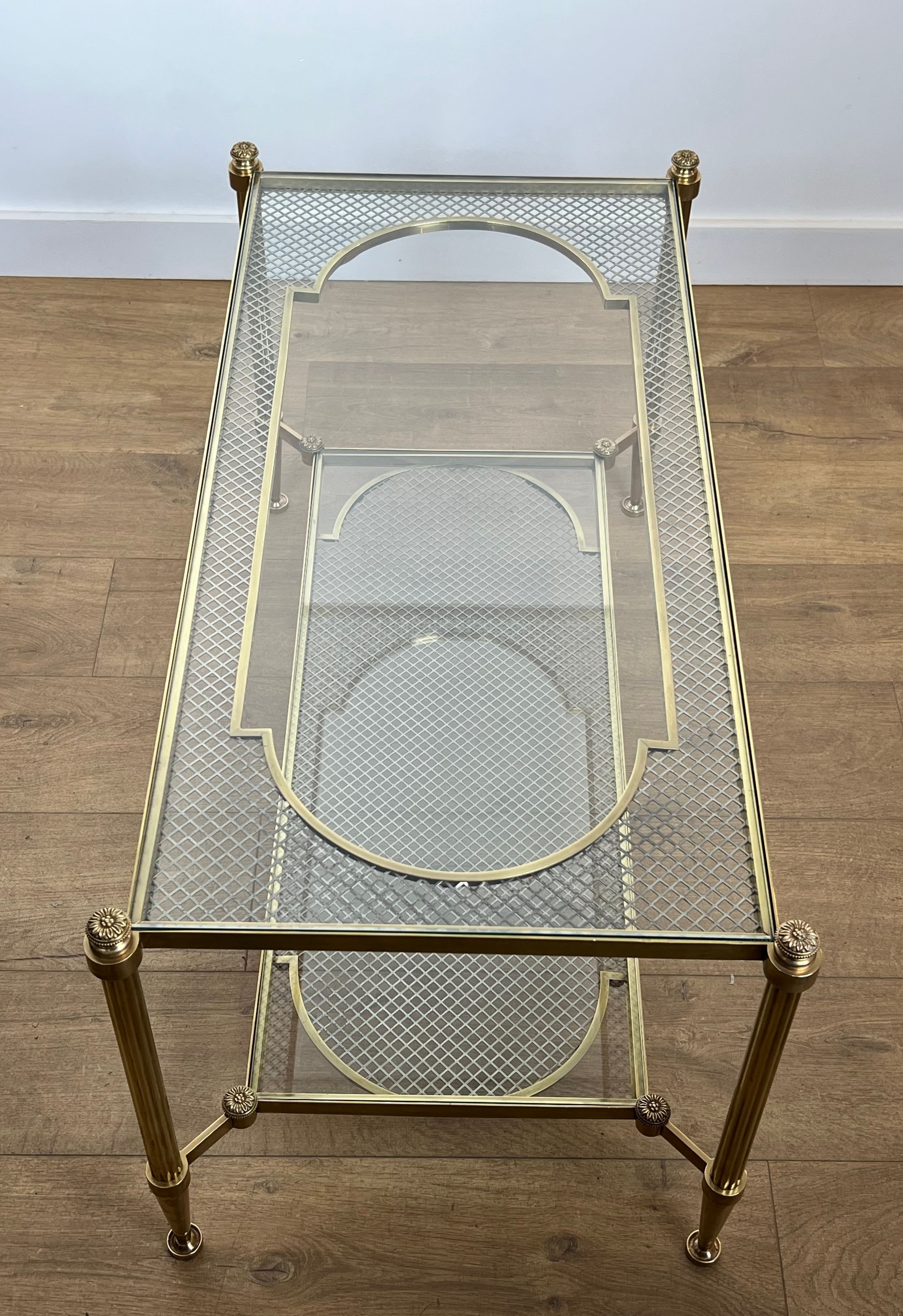 Rare bronze, brass, and steel mesh coffee table with a double glass top resting on a brass mesh. French work by Jansen