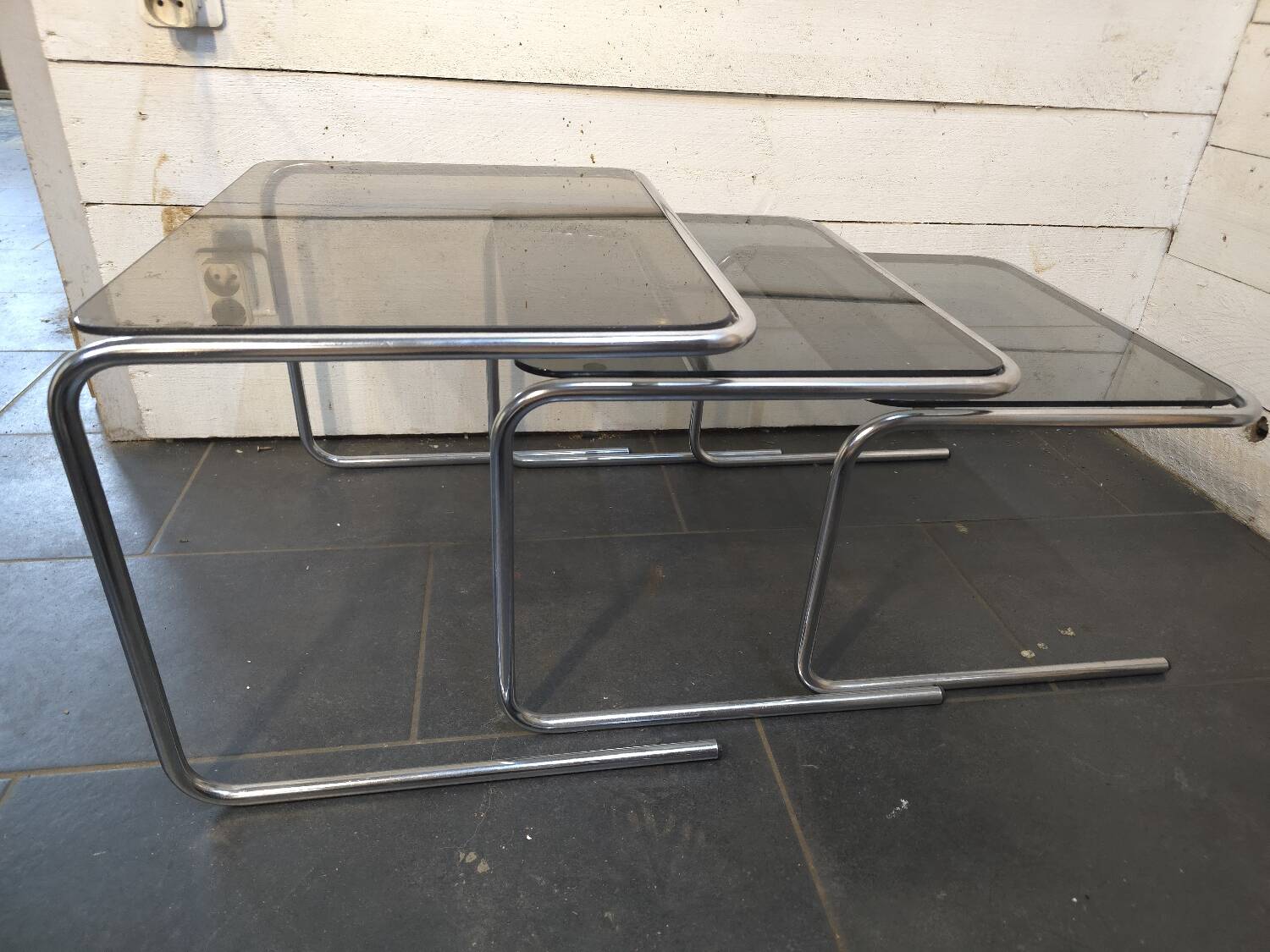 Nesting tables in chromed metal with smoked glass tops from the 1970s