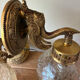 Pair of vintage wall sconces with golden metal swan heads and glass.