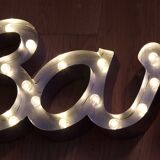 Enseigne lumineuse en lettrage aluminium formant le mot "bar"