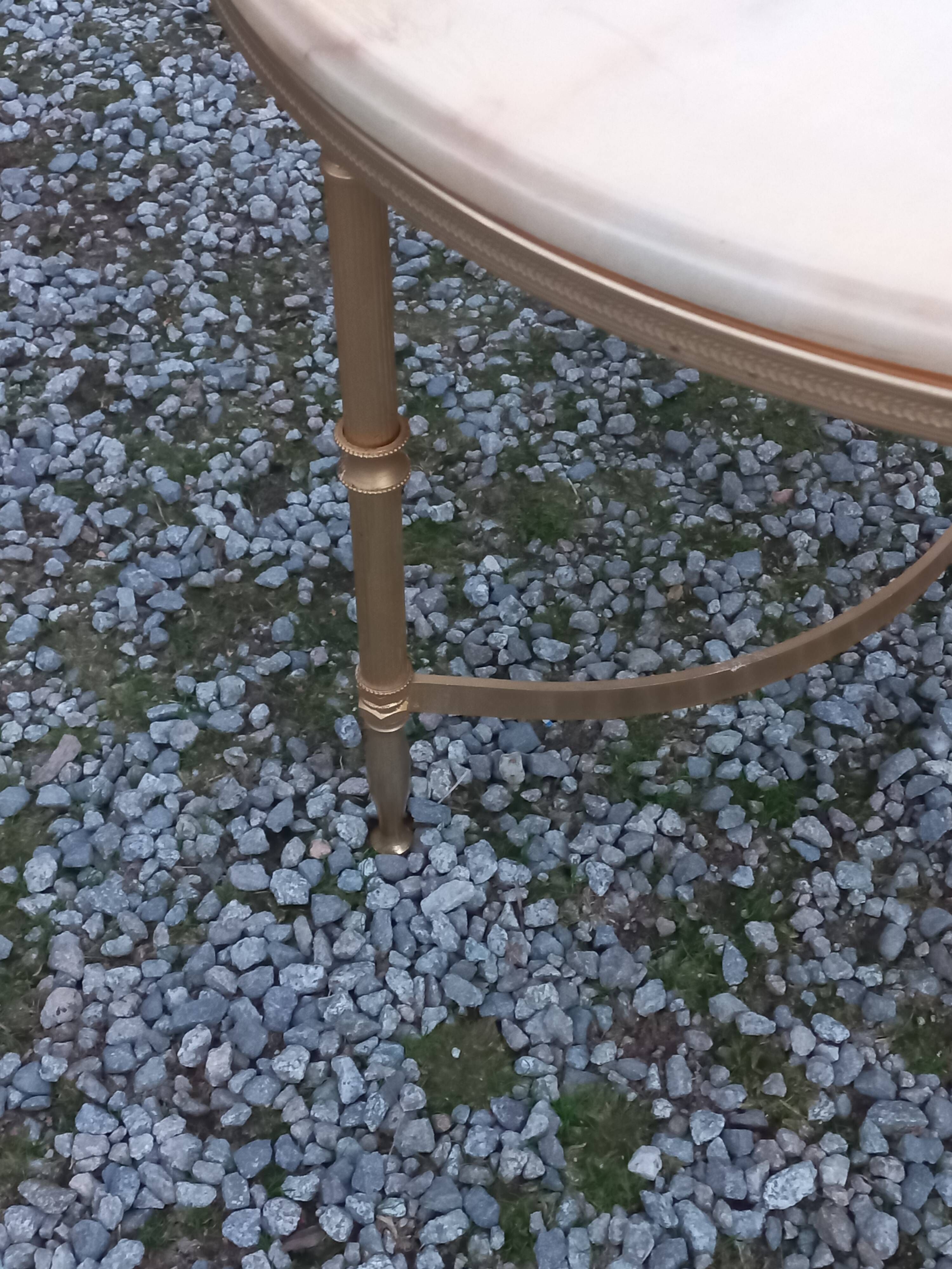 Round neoclassical coffee table with a marble top and golden metal base.