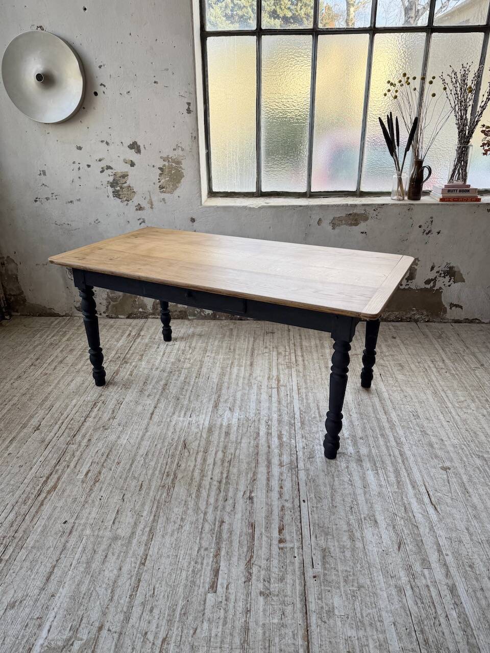 Oak farmhouse table with turned black legs.