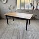 Oak farmhouse table with turned black legs.