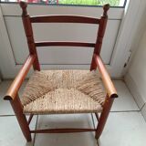 Children's wooden armchair and straw-covered seat.