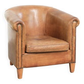 Sheepskin club armchair in a cognac colour finished with decorative nails