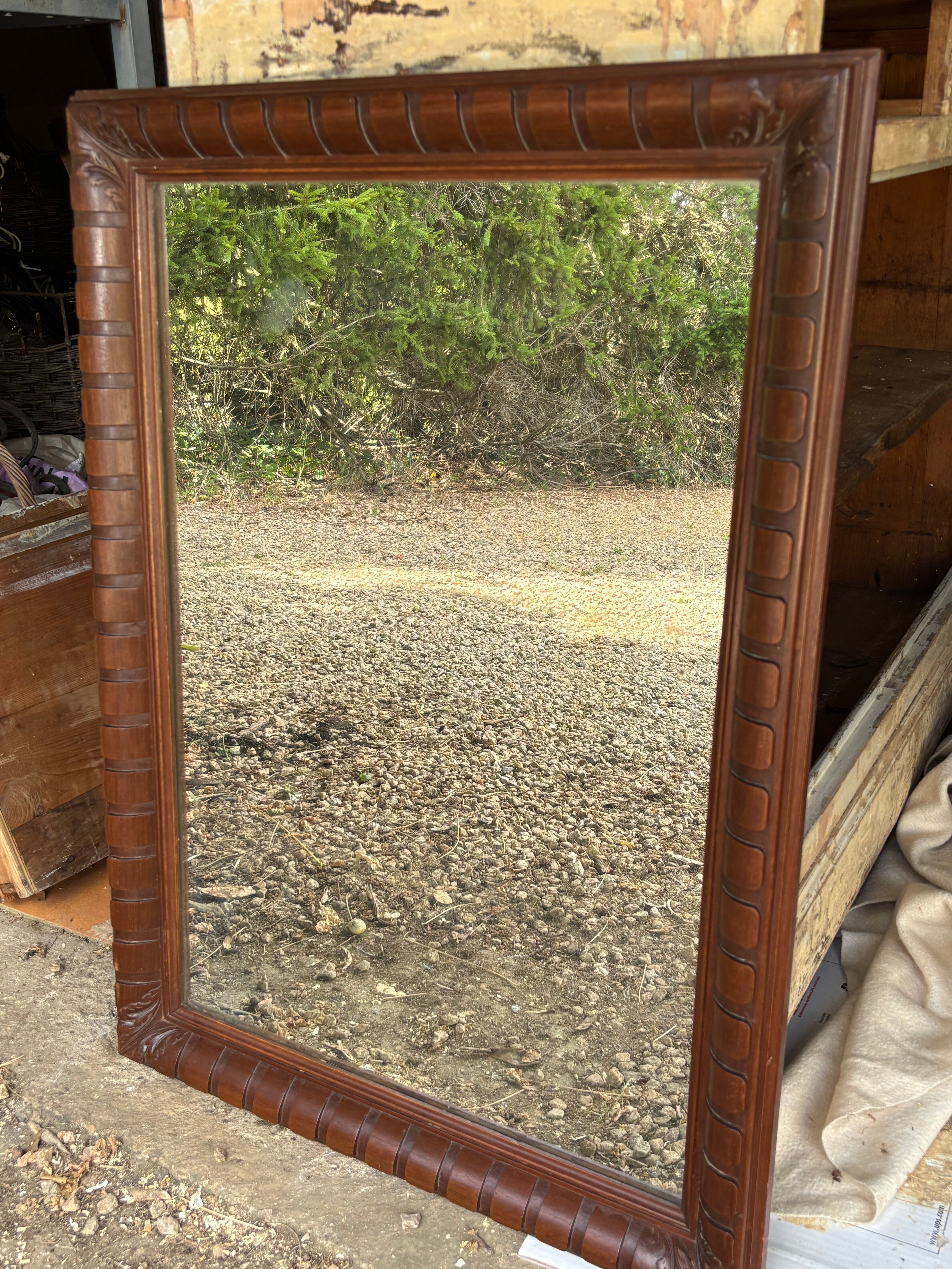 Large wall mirror with an elegant wooden frame.