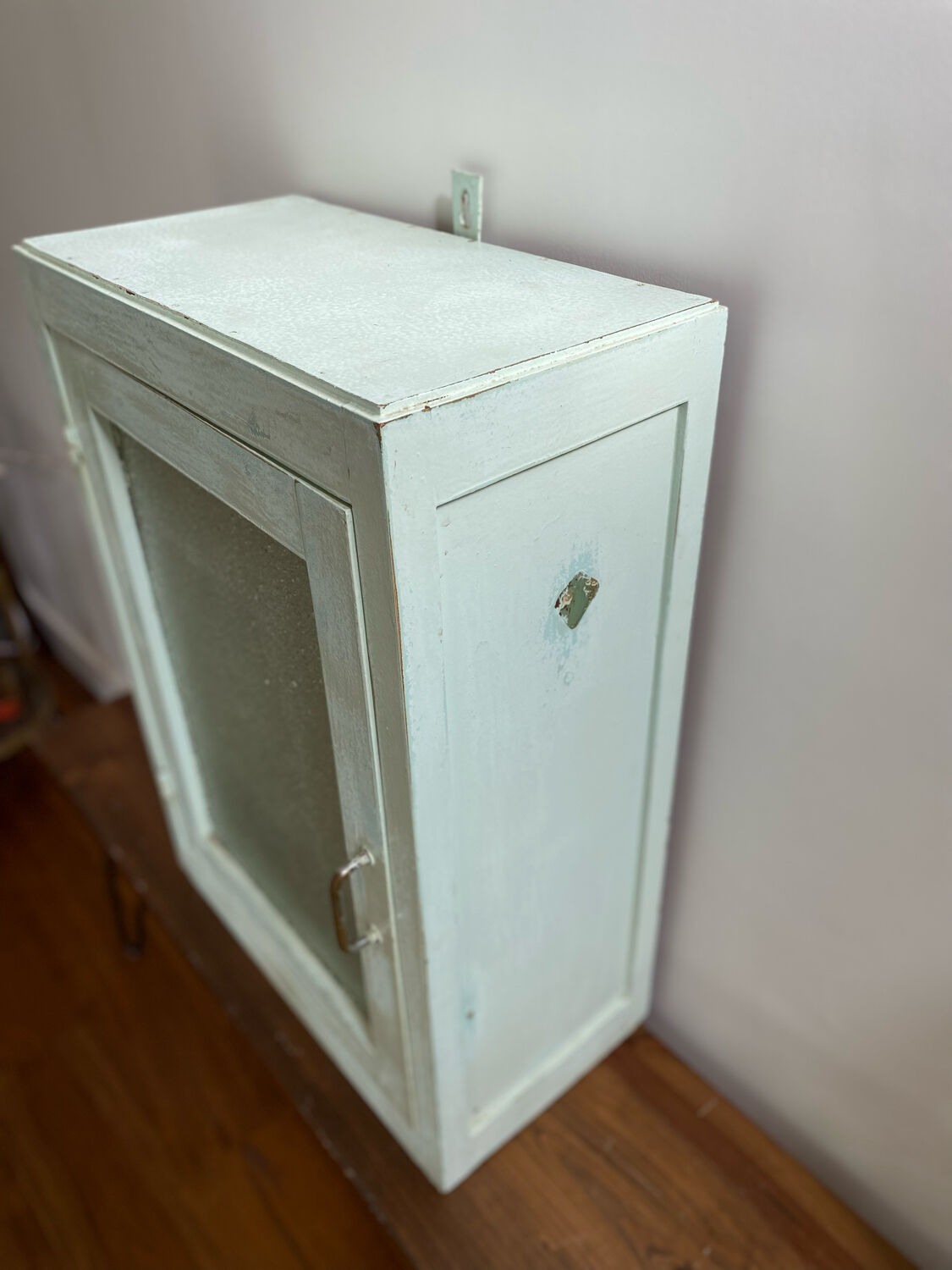 Old medicine cabinet in mint green patinated wood