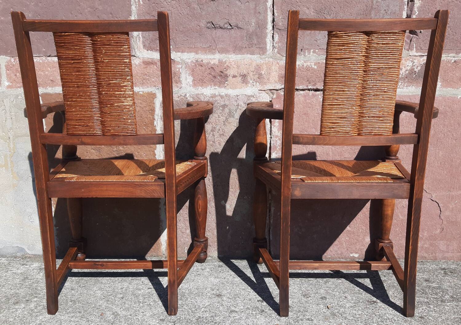 Pair of oak armchairs with straw seats and backs.