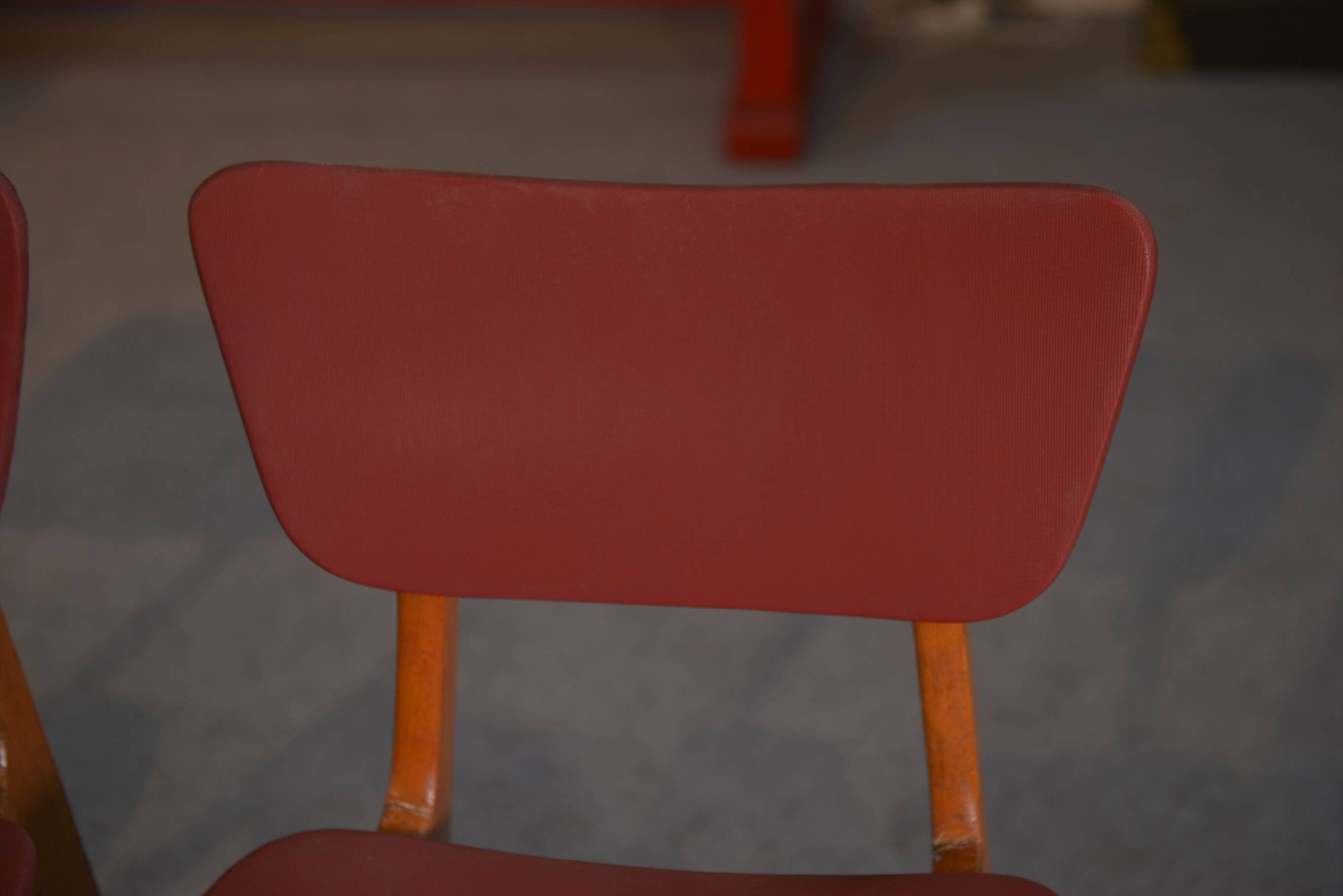 Set of 4 designer chairs in oak and red leatherette from the 1960s