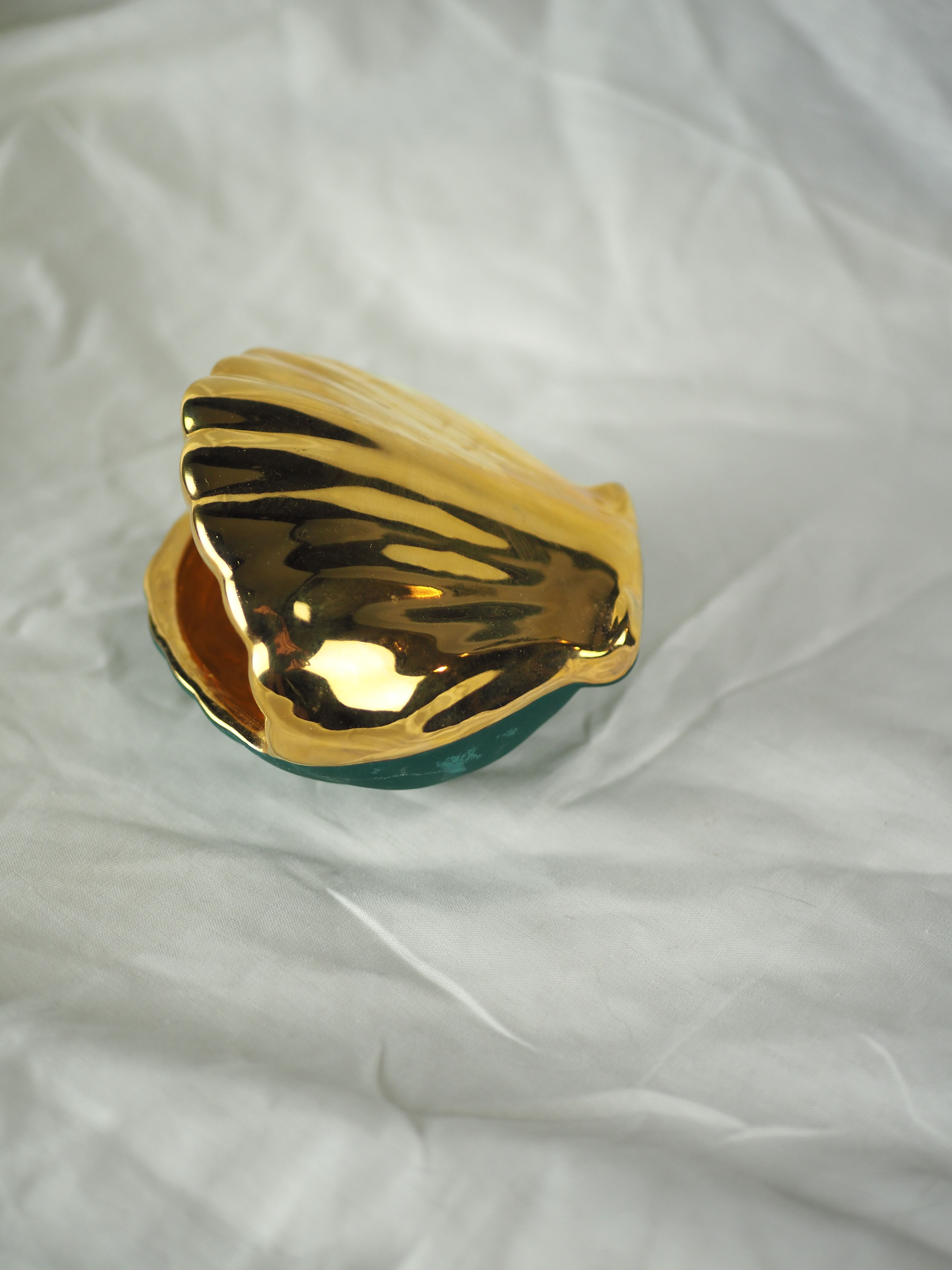 Porcelain pocket tray in the shape of a golden scallop shell with duck green background from the 50s/60s