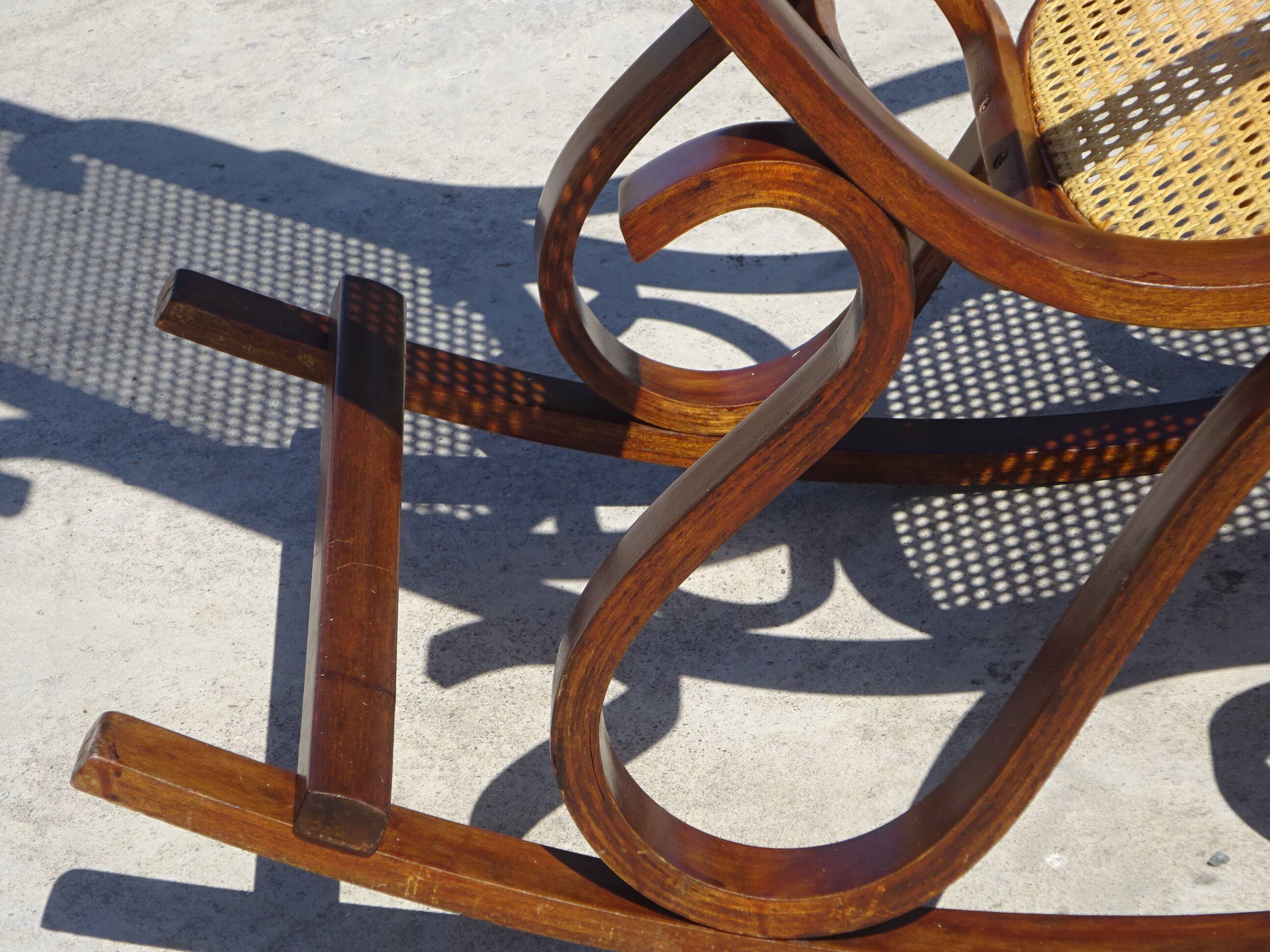Vintage wooden rocking chair with caning