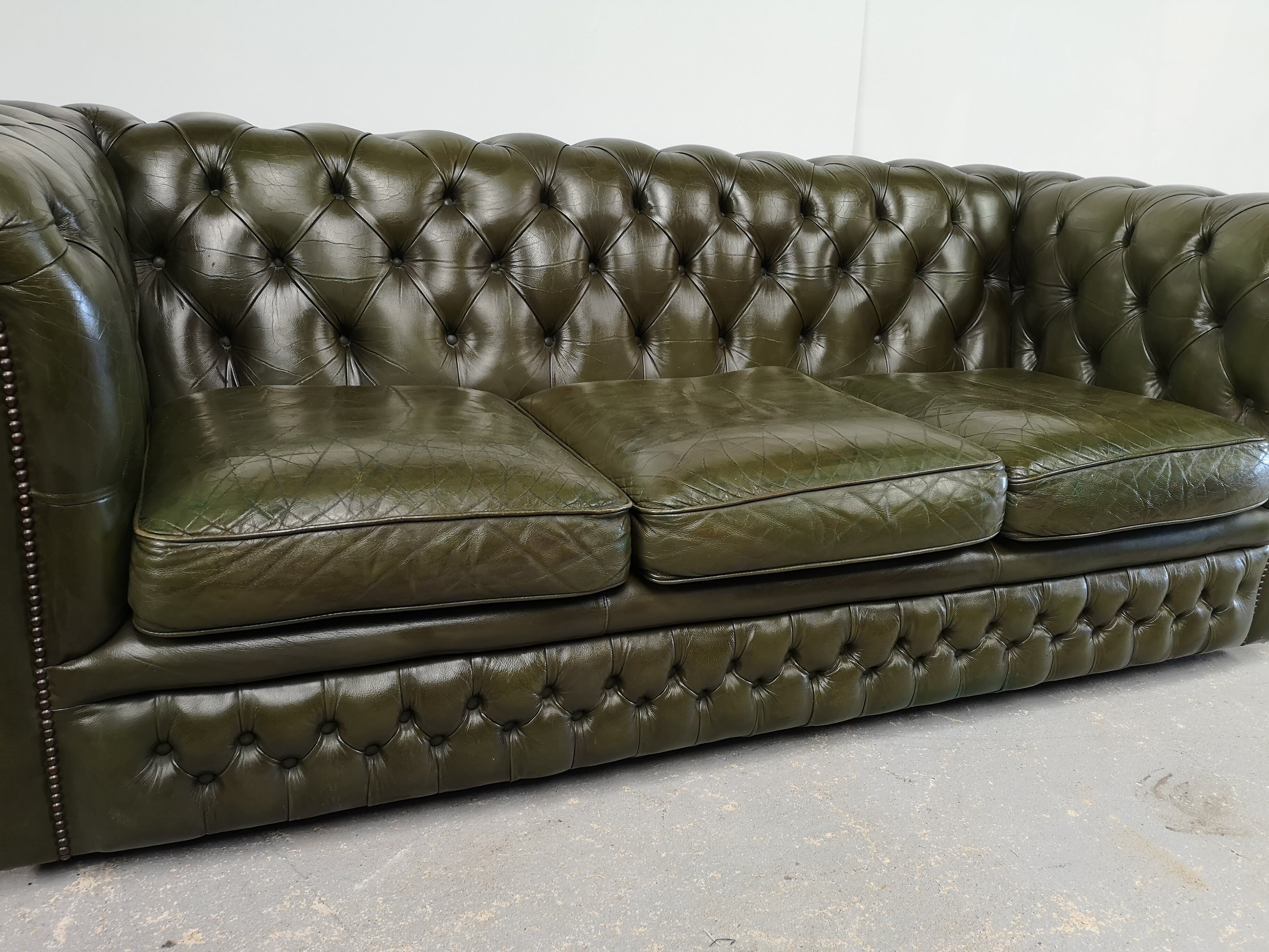 Three-seater green leather Chesterfield sofa