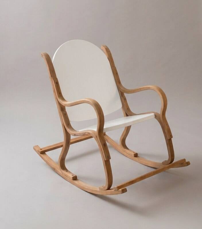 Handcrafted rocking chair in curved wood with a white seat.
