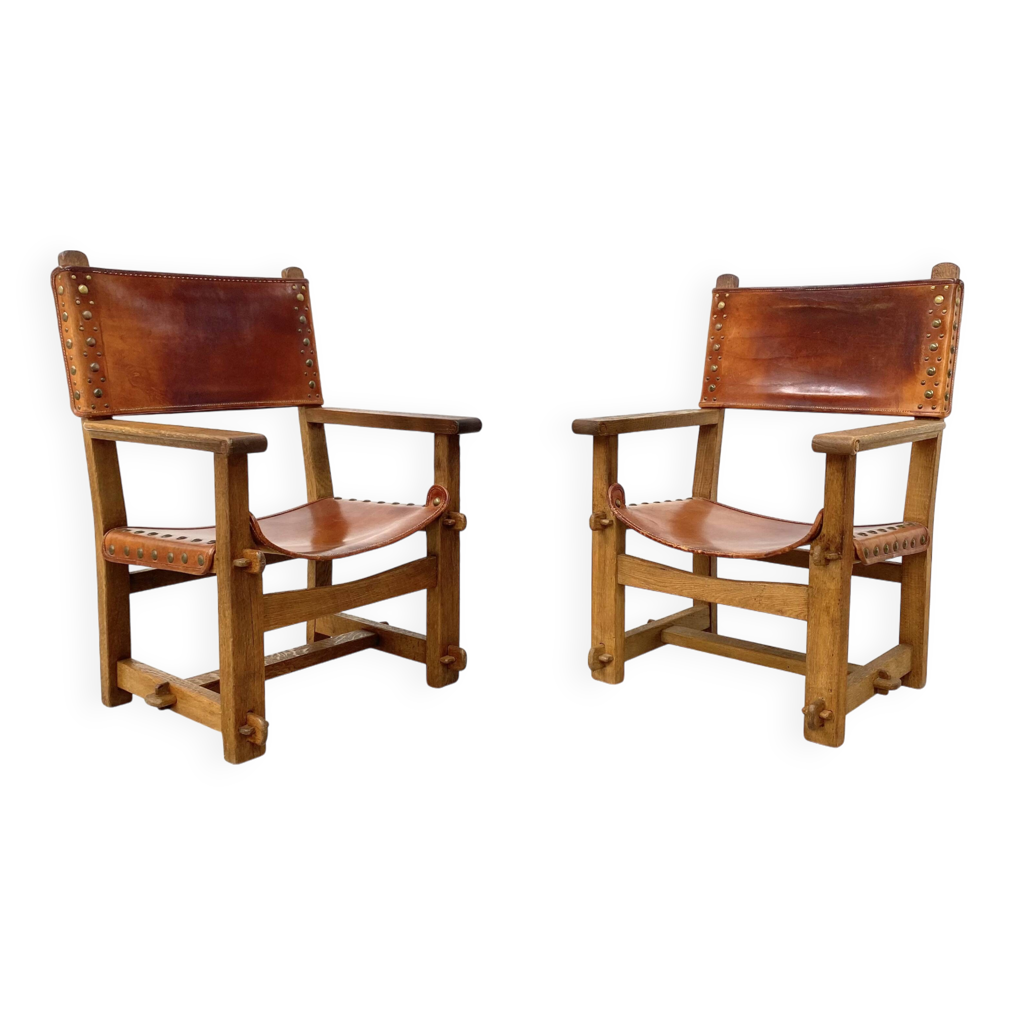 Paire de chaises de château brutalistes anciennes faites à la main en chêne et cuir cognac, années 1920.