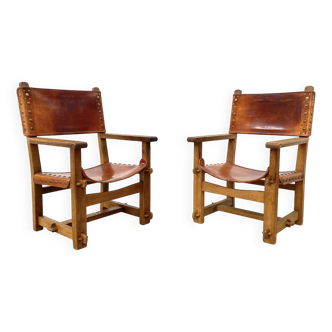 Paire de chaises de château brutalistes anciennes faites à la main en chêne et cuir cognac, années 1920.