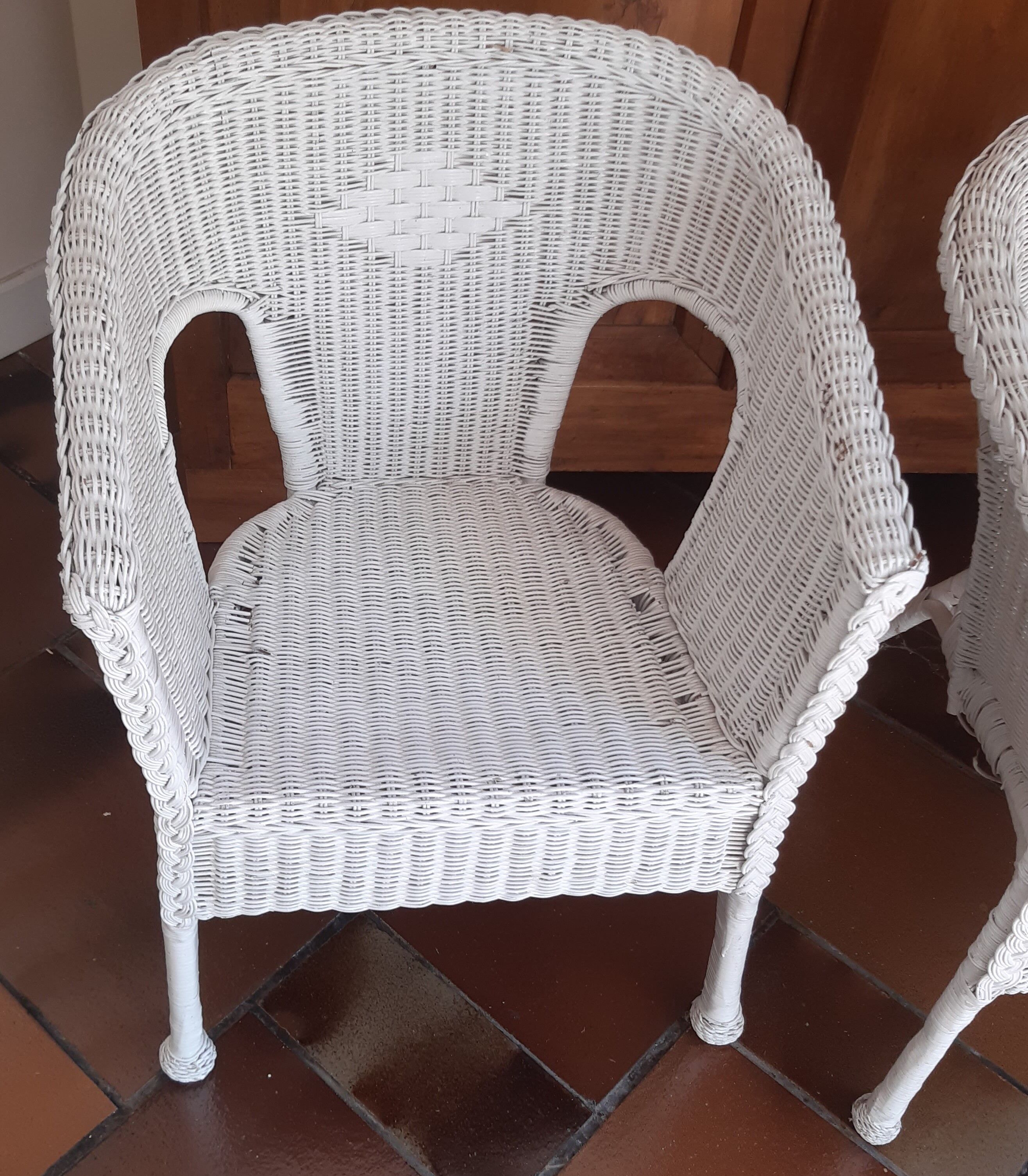2 white wicker armchairs