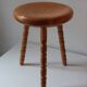 Vintage en bois tourné tabouret du milieu du siècle avec un siège épais.