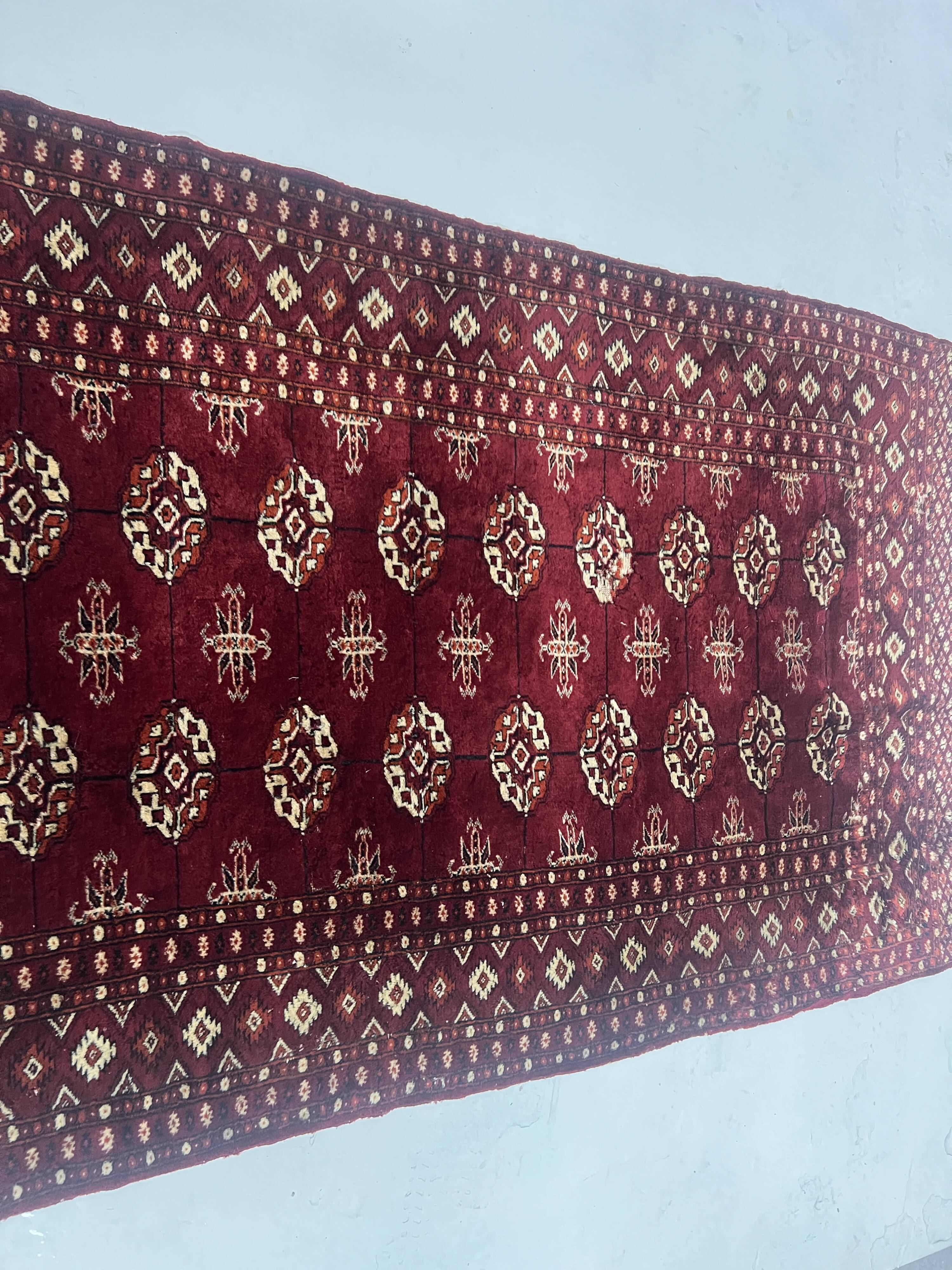 Antique wool rugs with designs on a red background, 20th century.