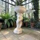 Vintage white concrete garden statue adorned with planter.