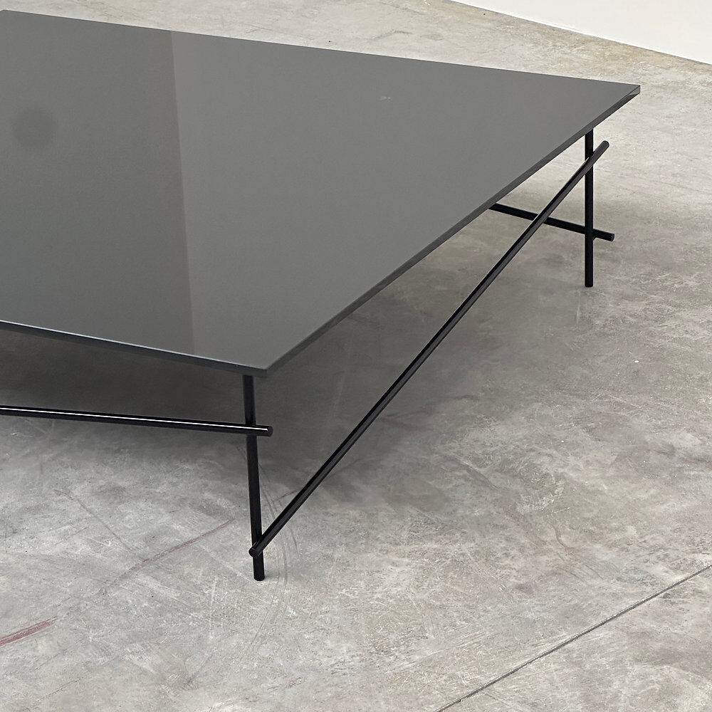 Minimalist black glass coffee table with industrial metal base