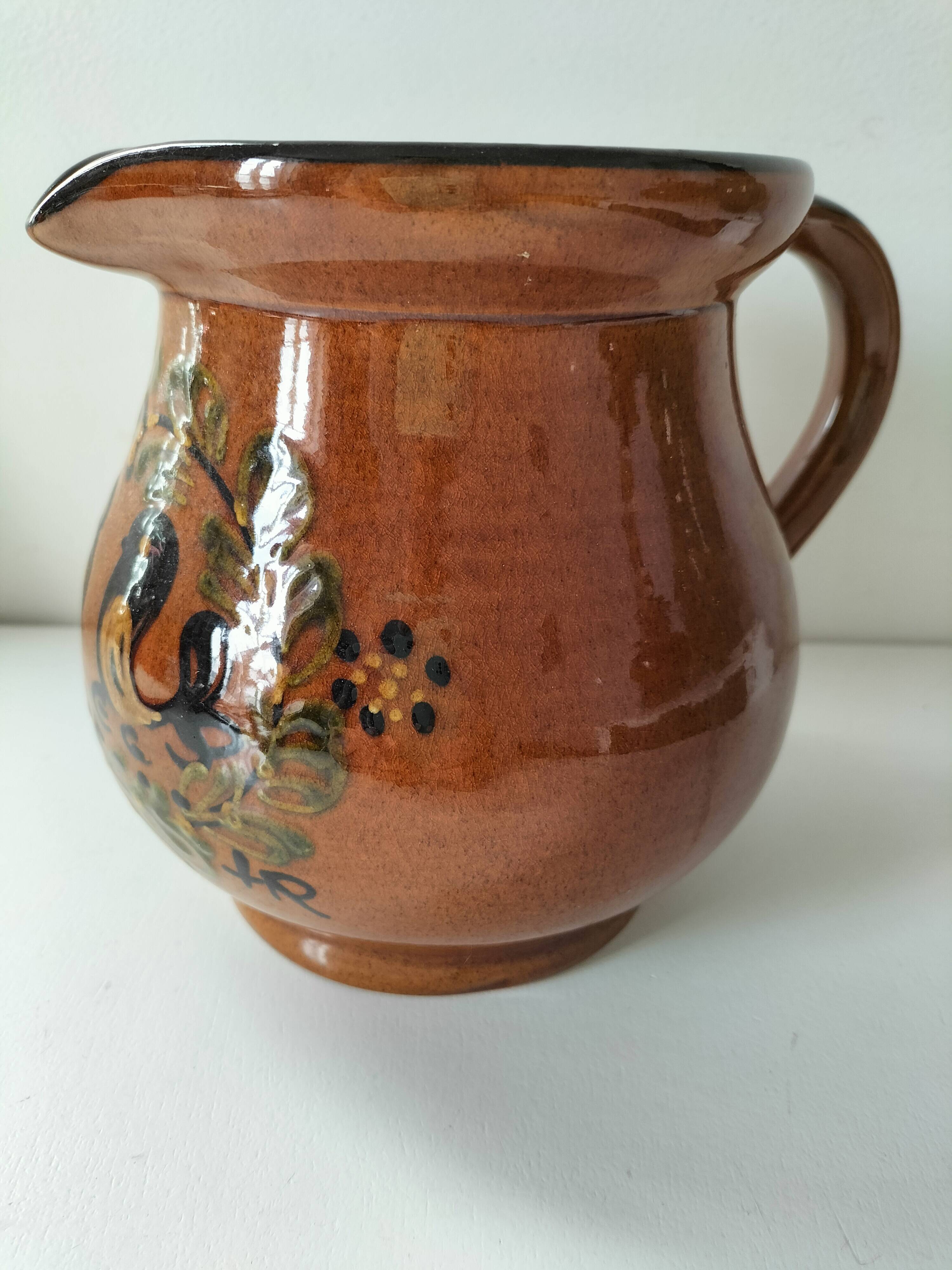 Glazed earthenware pitcher signed HR with a design of stylised birds.