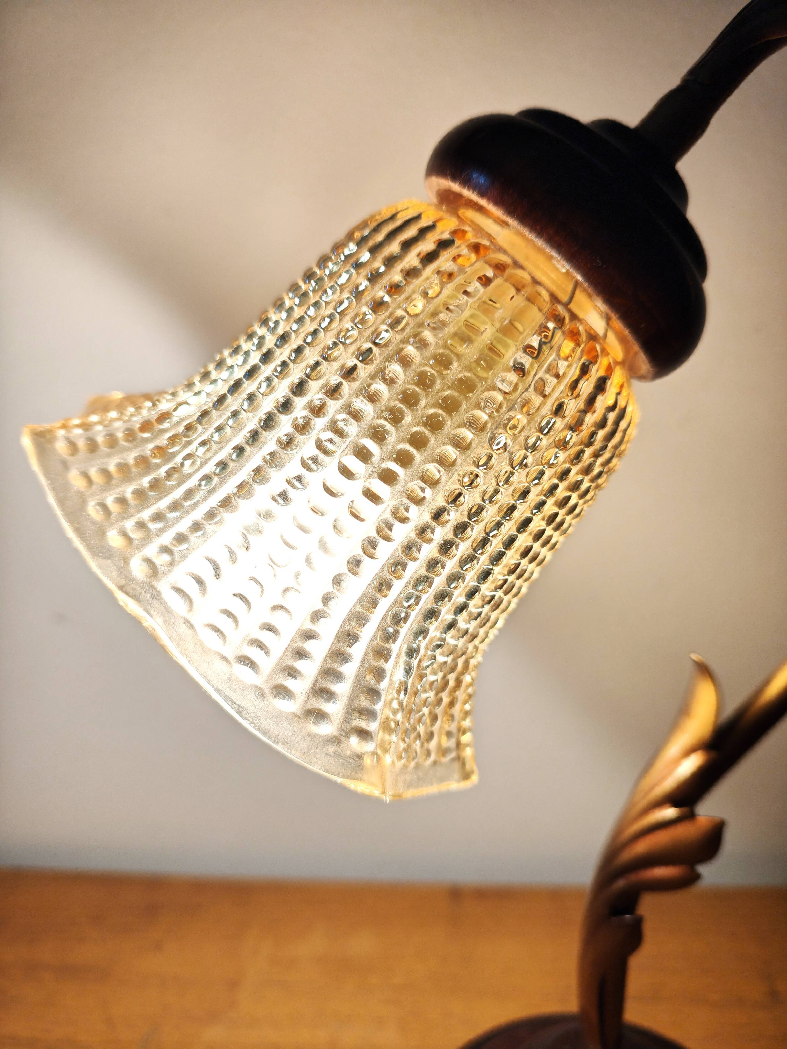 Gold swan neck table lamp with amber tulip glass.