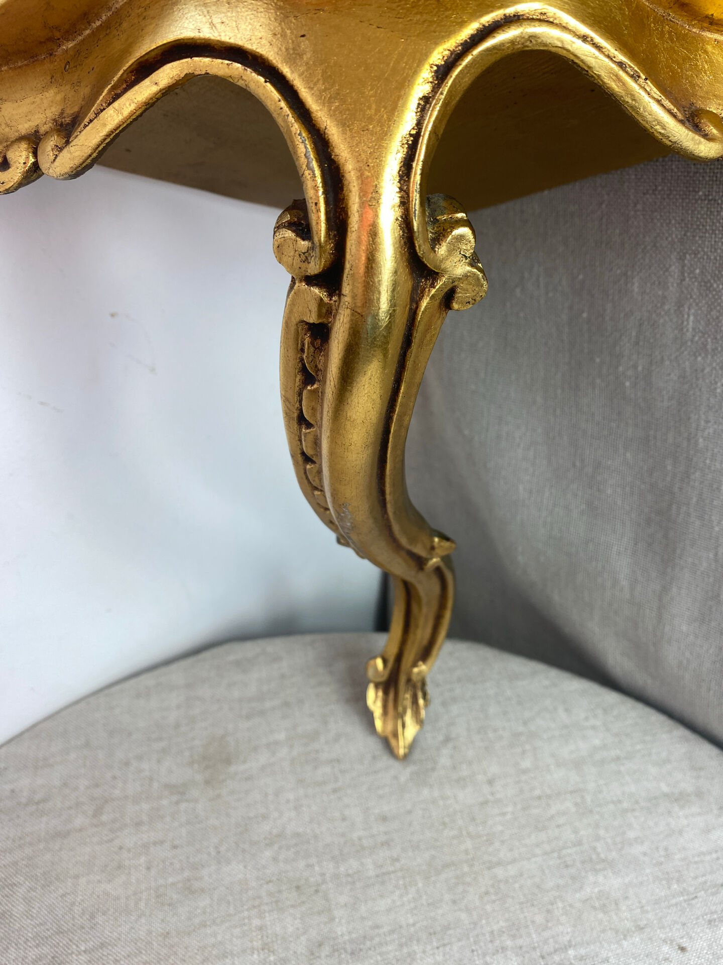 Small corner console in resin with a gold finish.