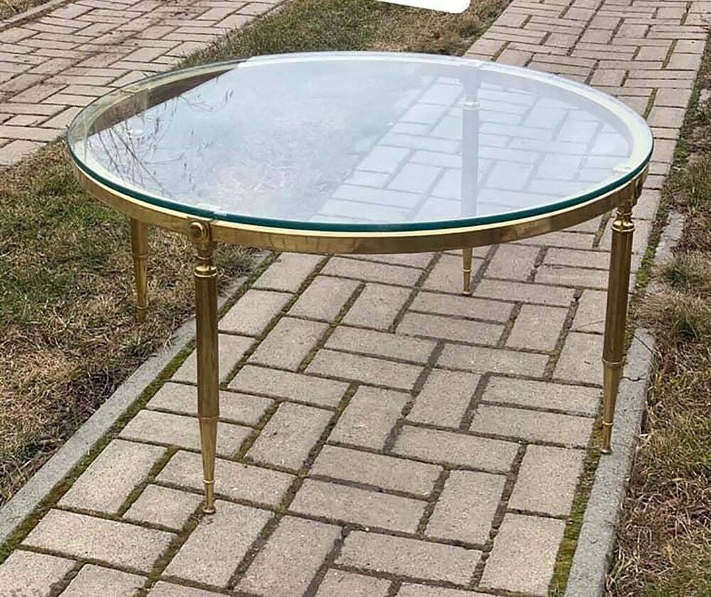 Round coffee table in gilded brass with a transparent glass top, 1960s design.
