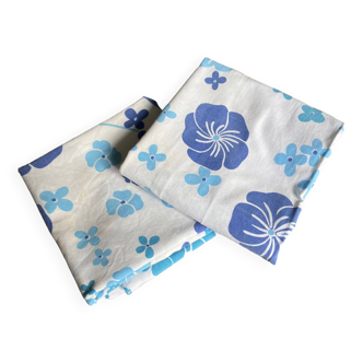 2 vintage cotton pillowcases with blue floral patterns.