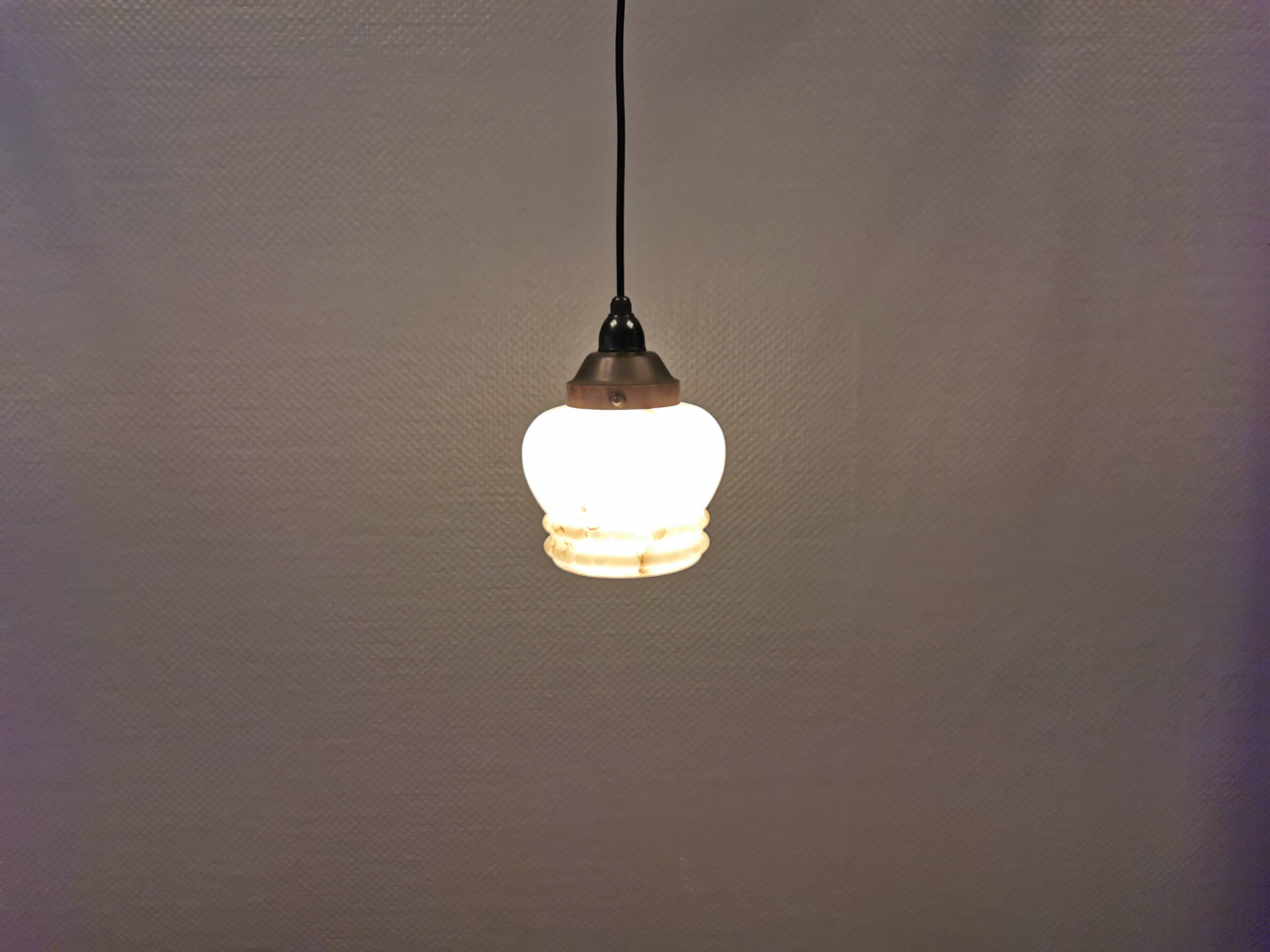 Small Art Deco hanging lamp in cream colored glass with bakelite top. Estimated 1950s