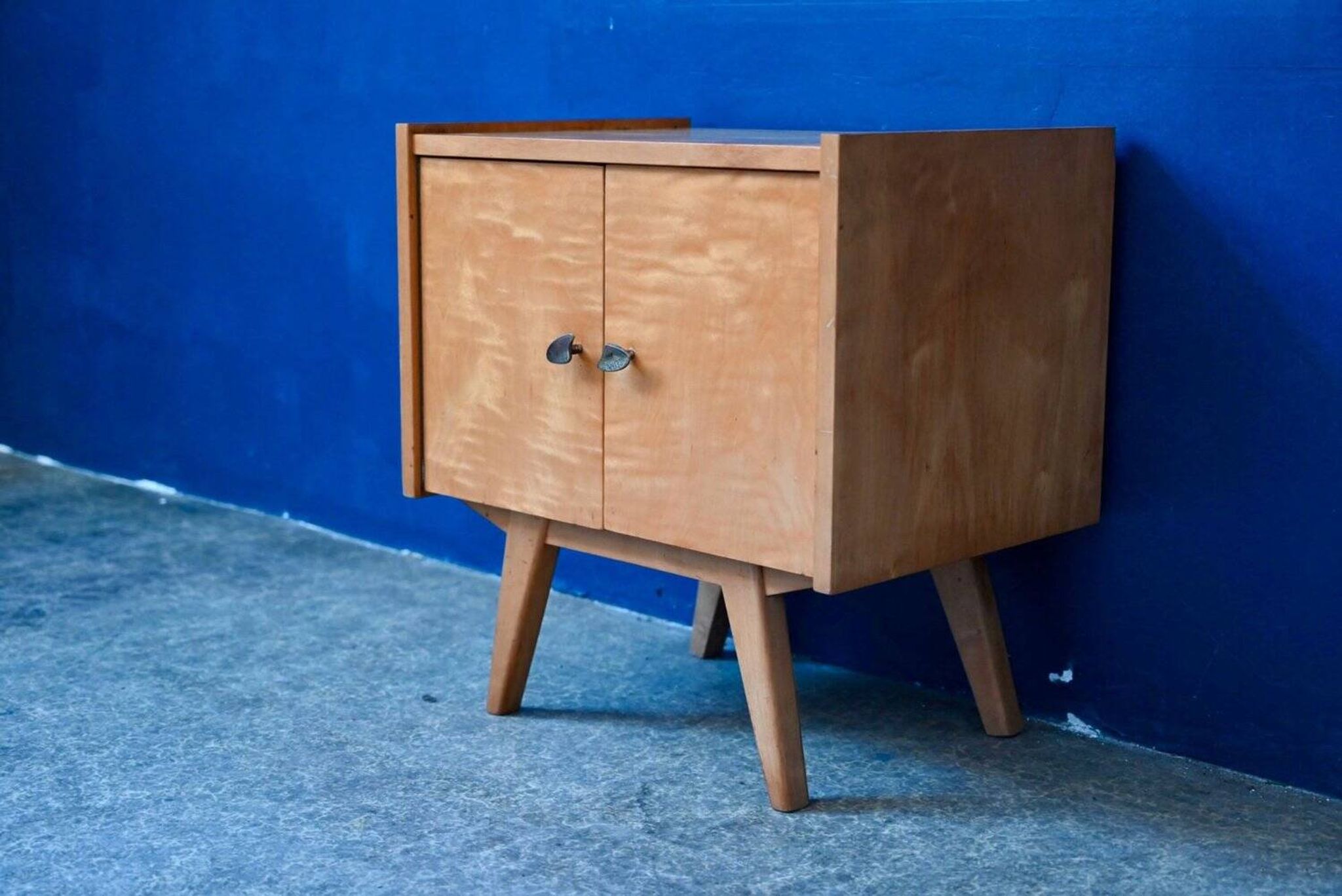 Rockabilly design bedside table with tapered legs.