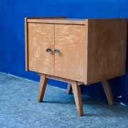Rockabilly design bedside table with tapered legs.