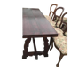 19th-century brown walnut dining table with sculpted trestle legs.