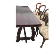 19th-century brown walnut dining table with sculpted trestle legs.