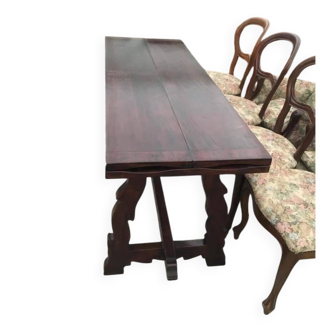 19th-century brown walnut dining table with sculpted trestle legs.