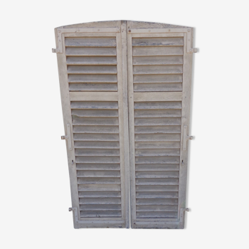 Pair of arched shutters with louvers