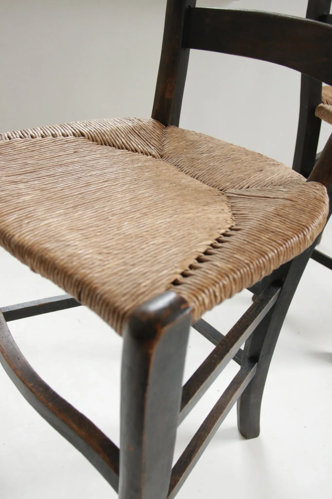 Pair of antique Northern French black-stained chairs with rush seats