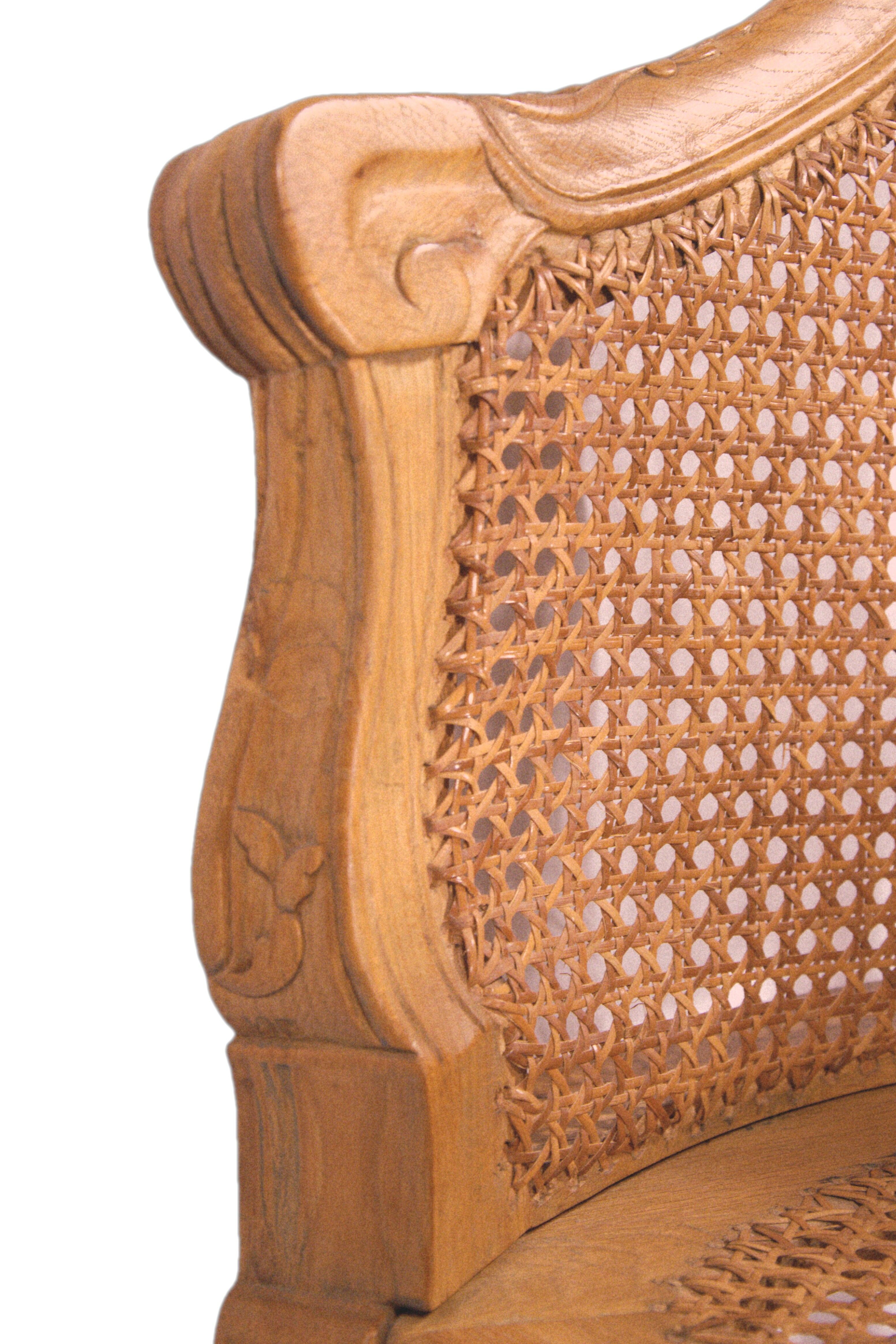 Armchair in solid oak with caning and a central leg (known as couillard), 89x68cm.