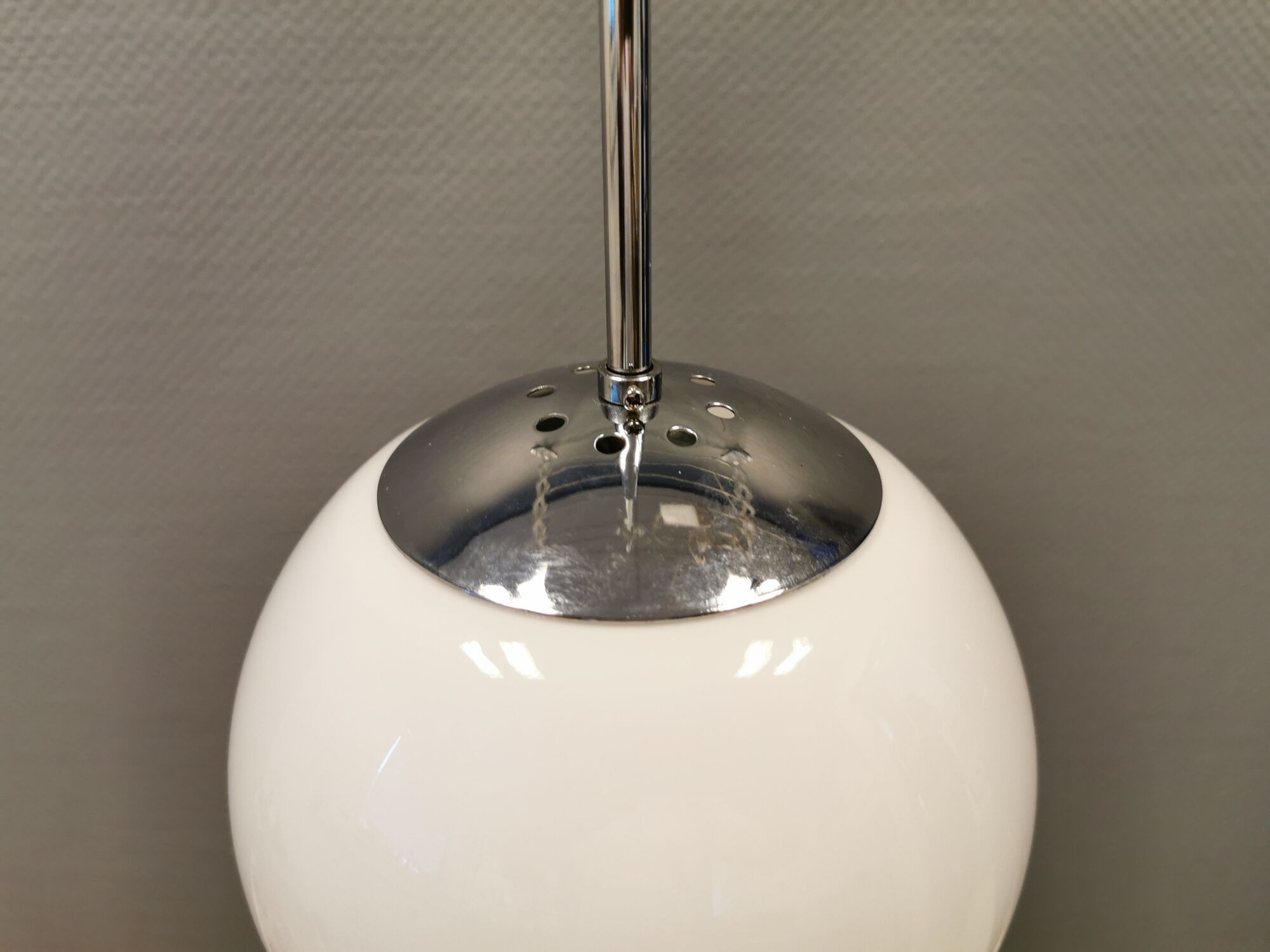 White hanging lamp with metal suspension, made with ball round opal glass shade.
