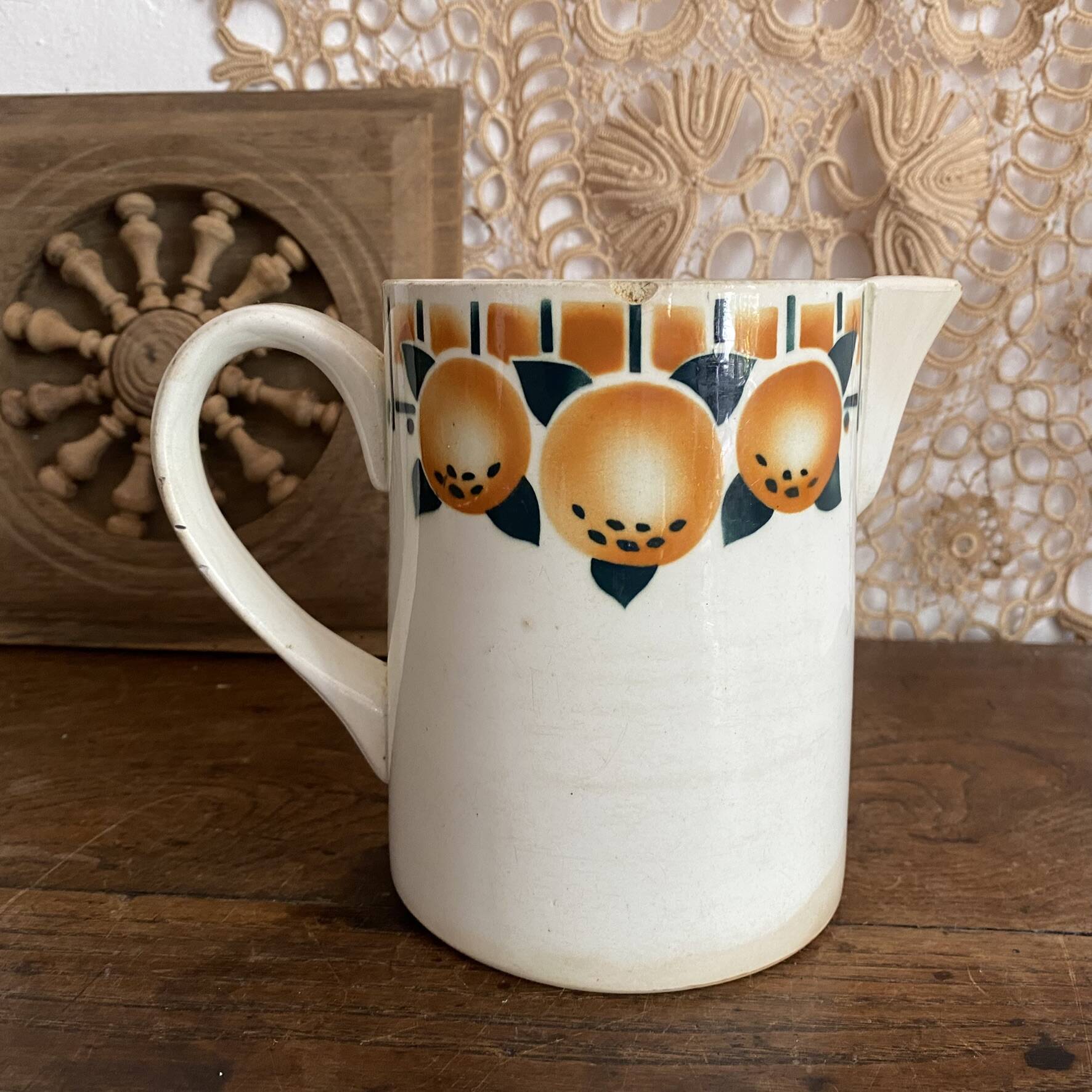 Old ceramic pitcher with orange decoration.