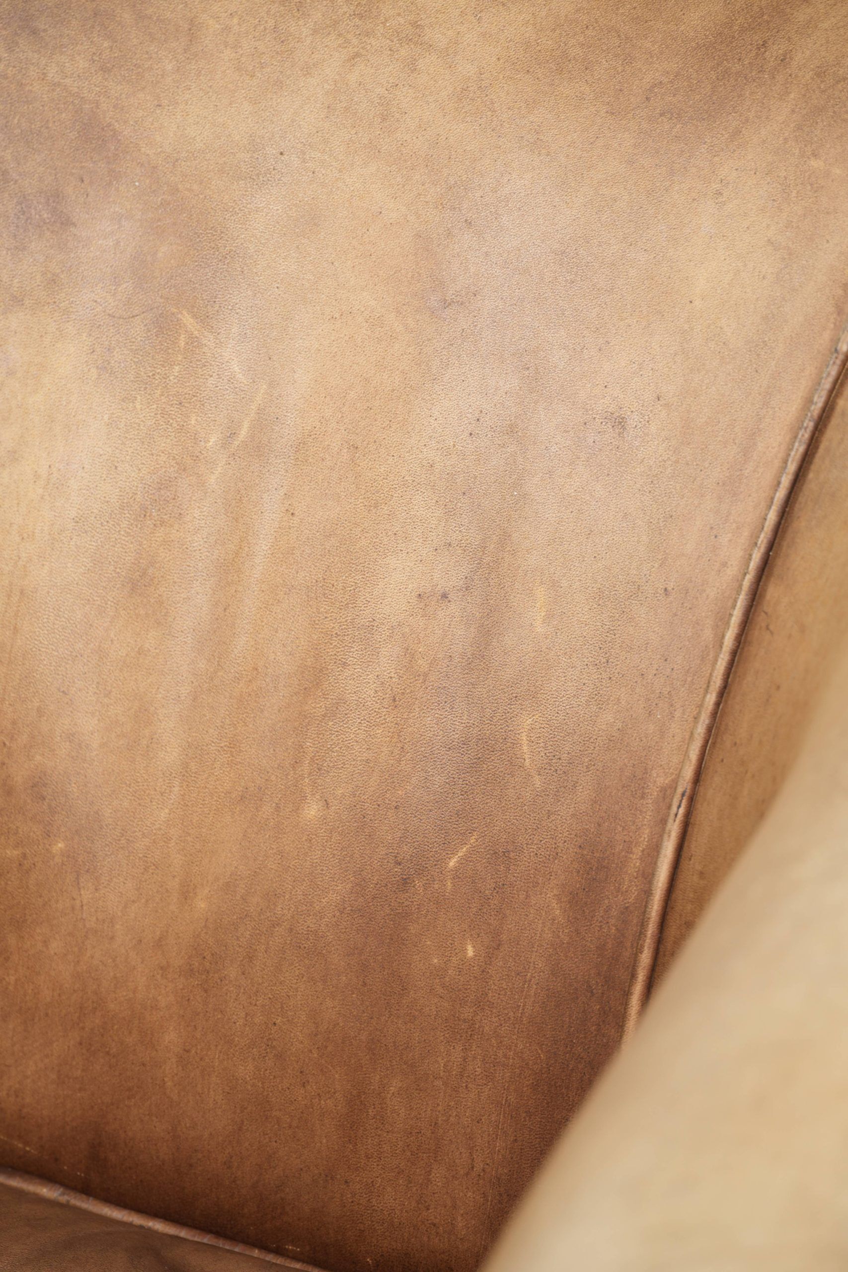 Vintage cowhide club armchair in English style in a light colour scheme